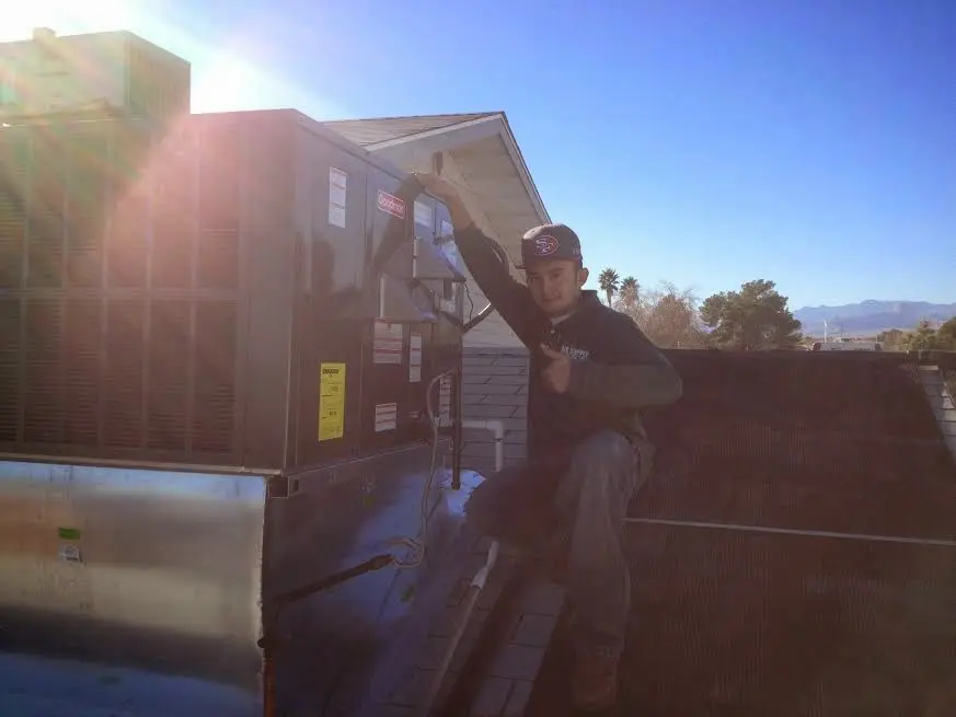 HVAC technician performing HVAC Inspection on a rooftop unit in Cortez