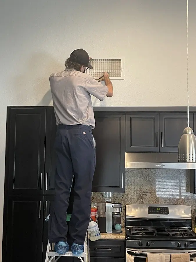 Technician inspecting an air vent during HVAC service in Cortez